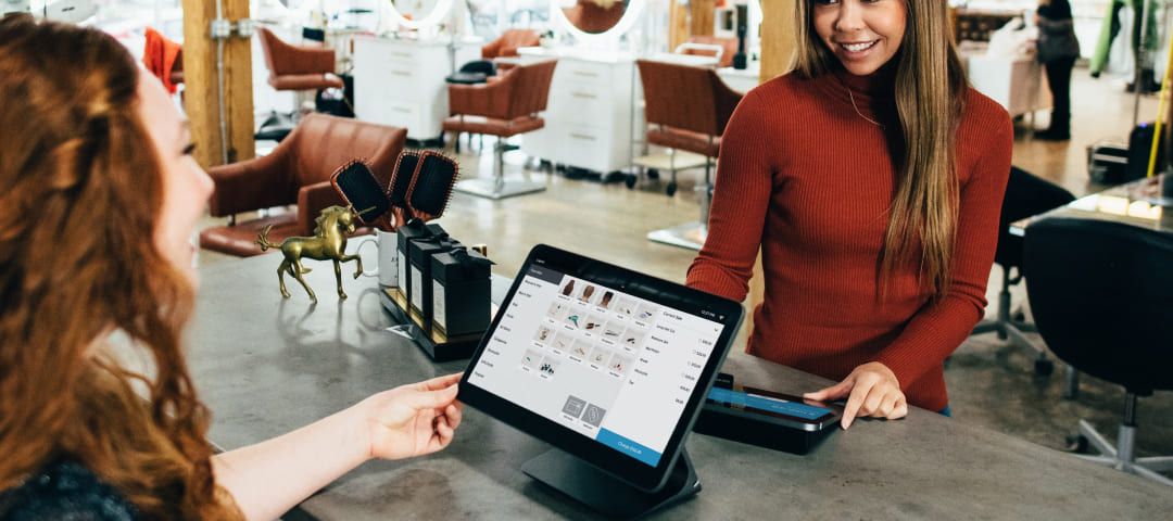 Photo of two women talking over a tablet