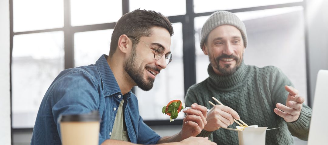 Male Couple Eating Lunch and Choosing Plans