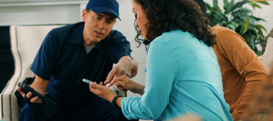 Photo of three people gesturing at something on a phone held by one of them