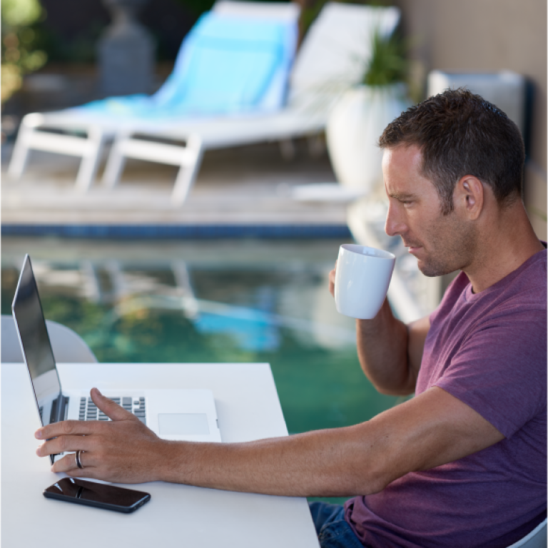 Using laptop by the pool