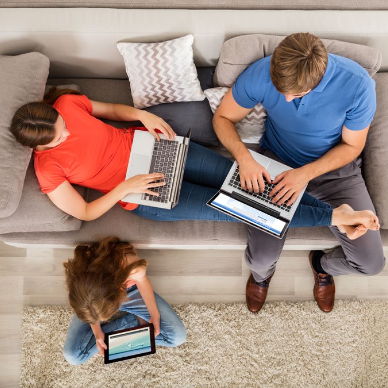 Family with laptops on the couch