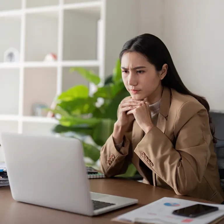 Looking concerned at laptop