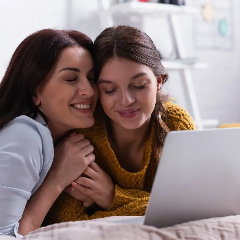 WTC Communications - Mother and daughter enjoying high-speed internet on a laptop at a home.